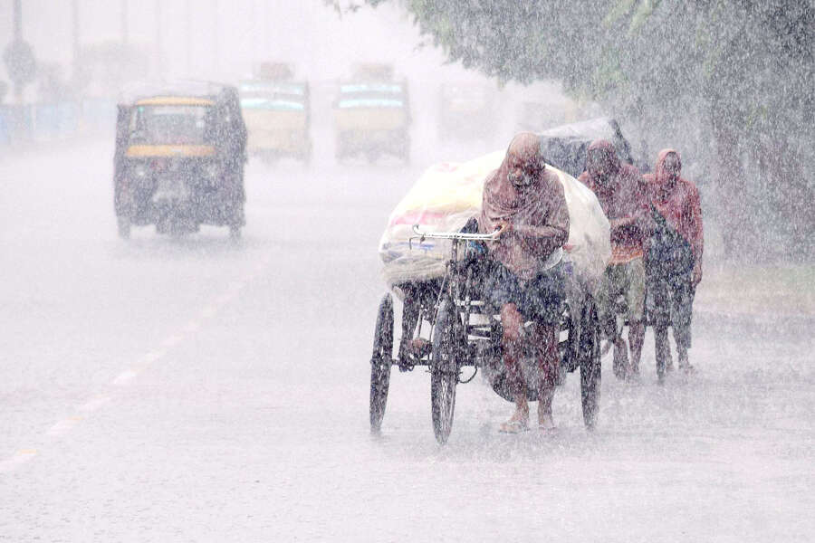 People move at a road in heavy Monsoon