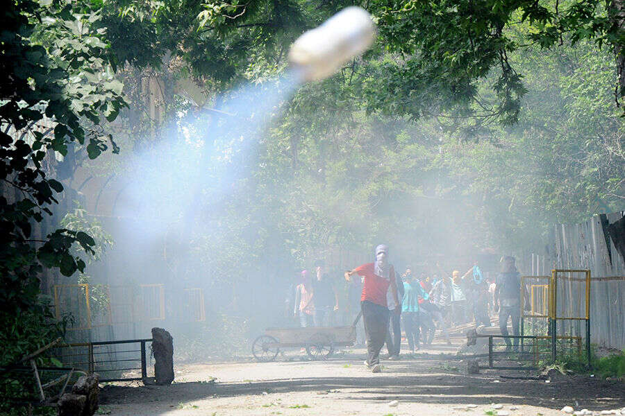 Tear gas being thrown back at the policemen