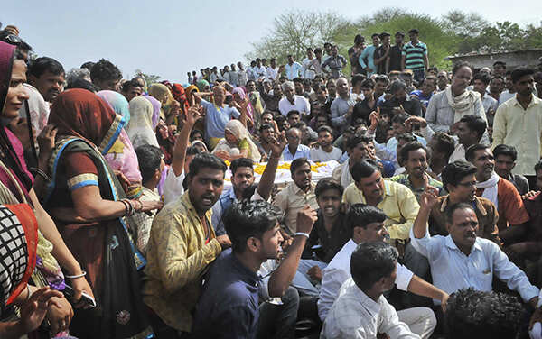 ​Villagers protest with the body of a farmer