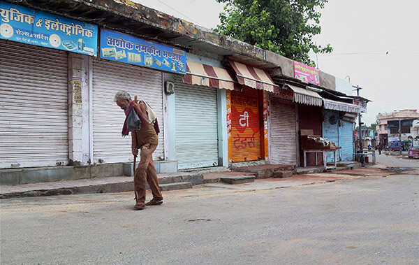 An old man walks past closed shops