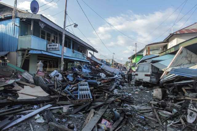 A man walks on a street after an earthquake and tsunami hit the area in ...
