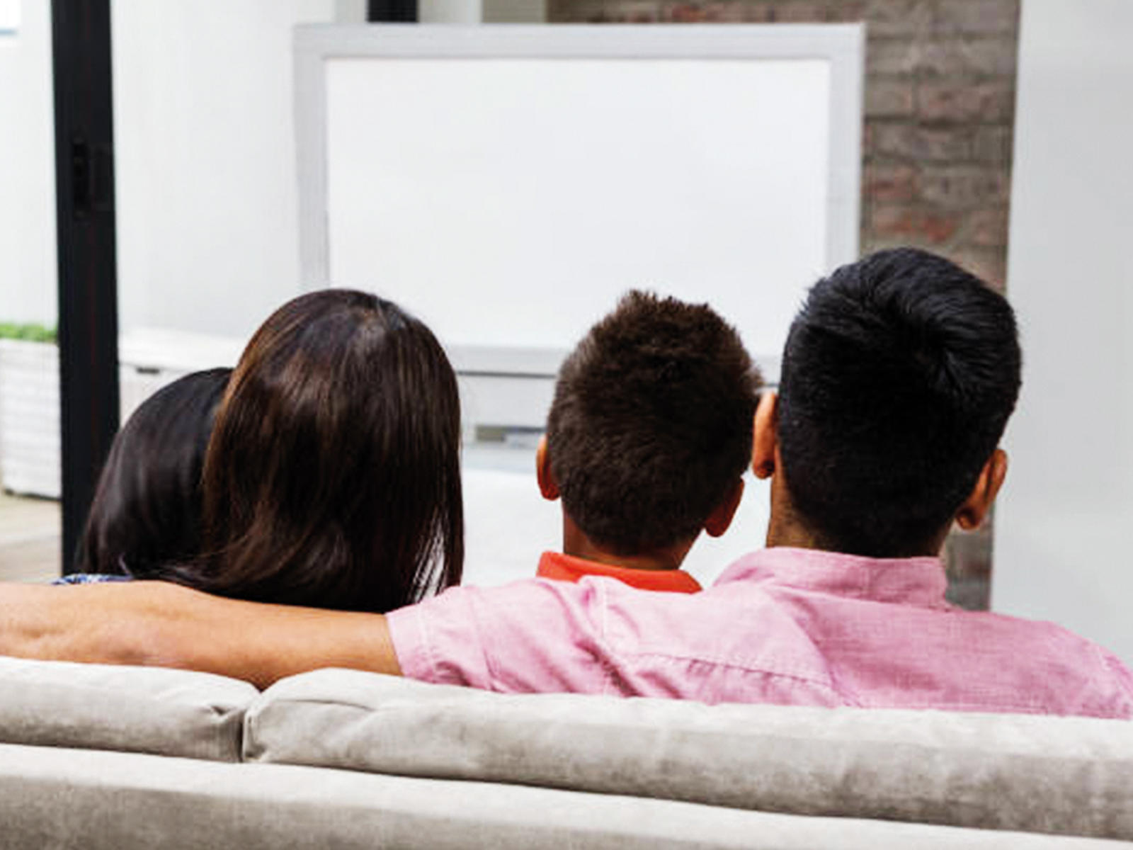 Совместный наблюдать. Семья на диване со спины. Family watching TV on a Burgundy Sofa.
