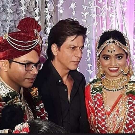 Shah Rukh Khan happily poses for pictures as he attends a wedding