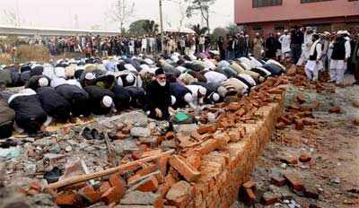 Security persons keep vigil as people prepare to offer prayers near the ...