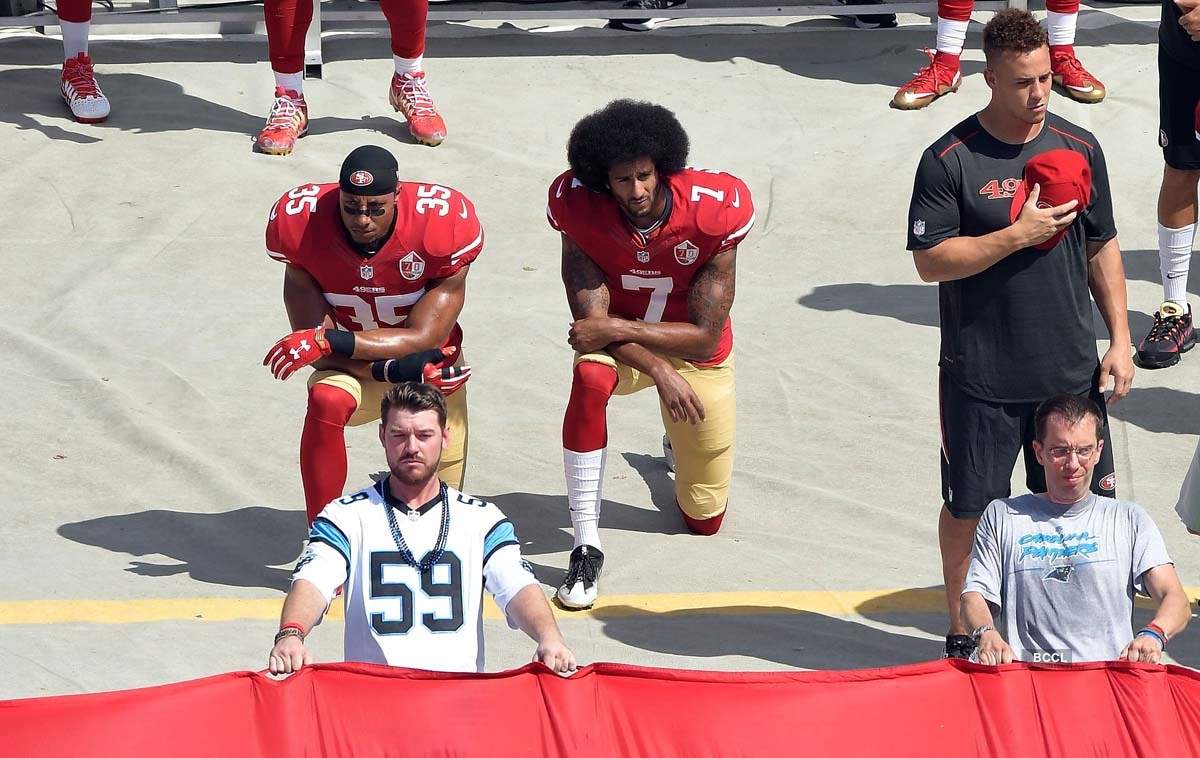 Pictures of African American NFL star Colin Kaepernick, who protested against police brutality four years ago