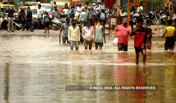 A Man Wades Through The Water After A Heavy Rain In Bengaluru ...