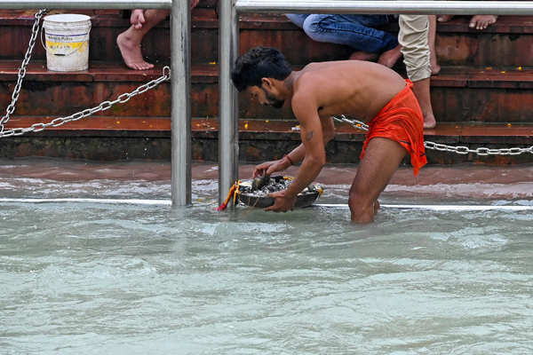These pictures show how locals fish out coins at Kumbh Mela