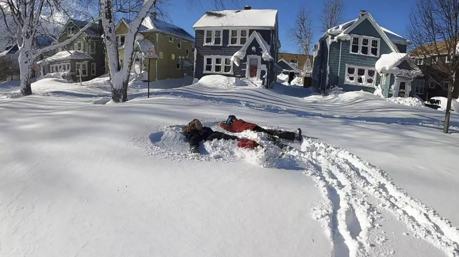 This photo provided by Clare Purcell shows two people making snow angels after a...