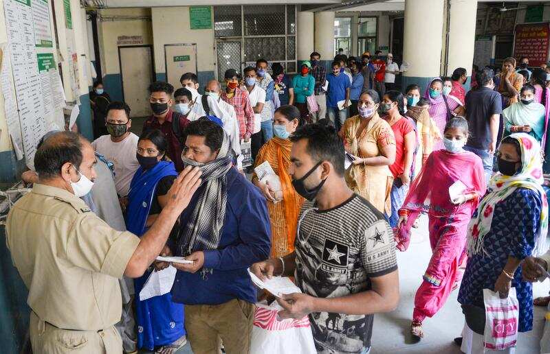 People wait in a queue for general checkup at government hospital, amid a surge in Coronavirus cases across the country, in Jalandhar
