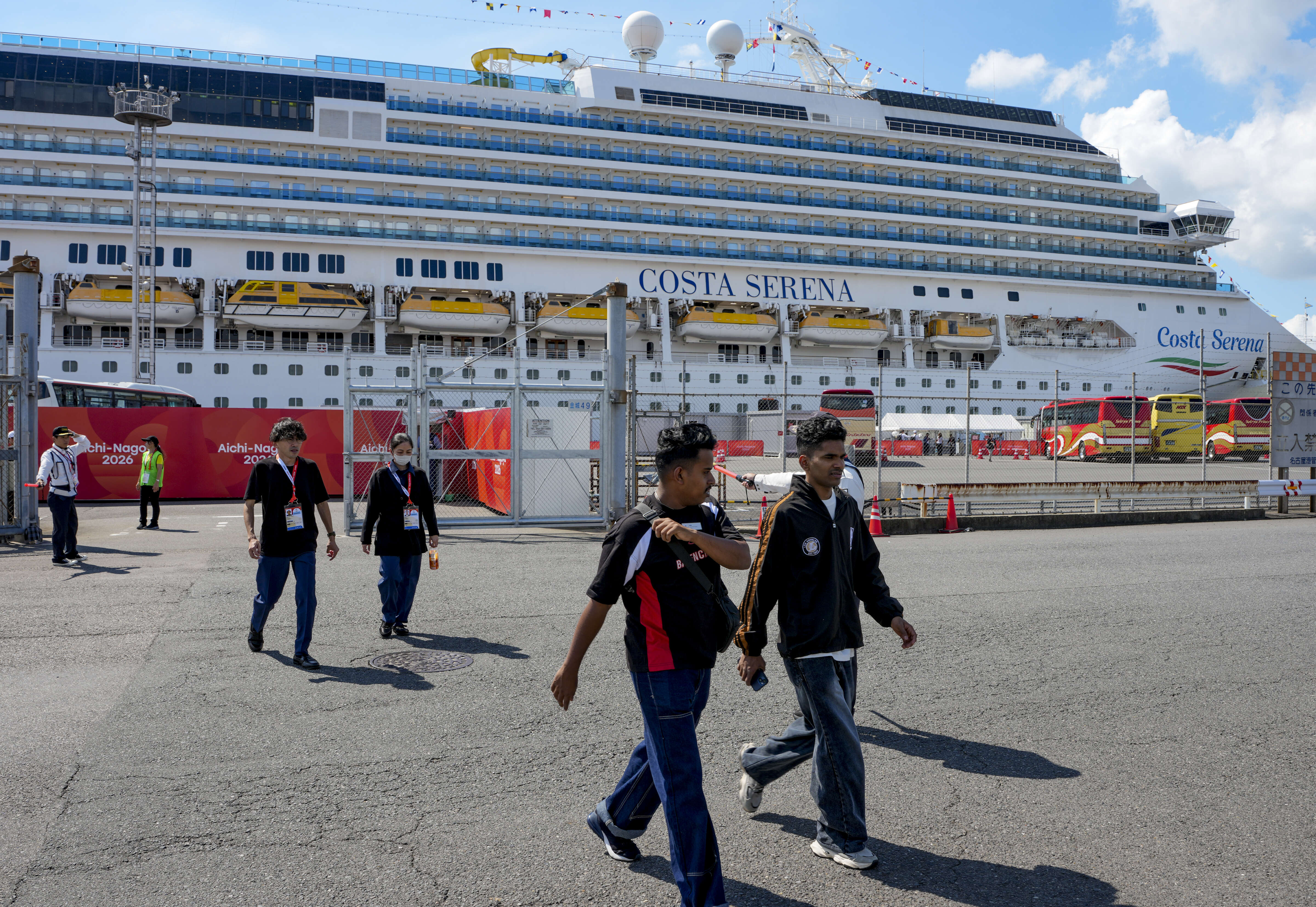 People walk past the Costa Serena cruise ship, housing athletes for the Asian Games, at Nagoya Port, Japan. (PTI Photo)