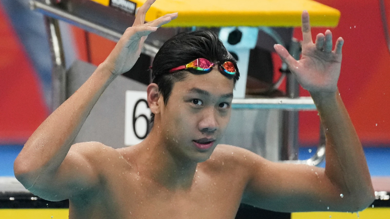 After touching the wall, Zhang sat on the lane line and counted his medals on his fingers. “1, 2, 3, 4, 5, 6, 7!”