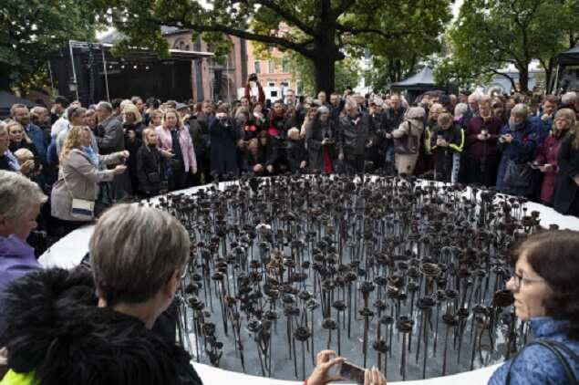People look at the newly unveiled memorial 'Iron roses' is unveiled outside Oslo Cathedral, in Oslo, Sept 28, 2019. The memorial is in memory of the 77 people who lost their lives on July 22, 2011 during a bombing and shooting attacks. (AP)