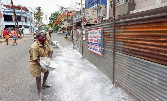 Corporation workers sanitize a road in a containment zone, during Covid-induced lockdown in Coimbatore. (PTI photo)