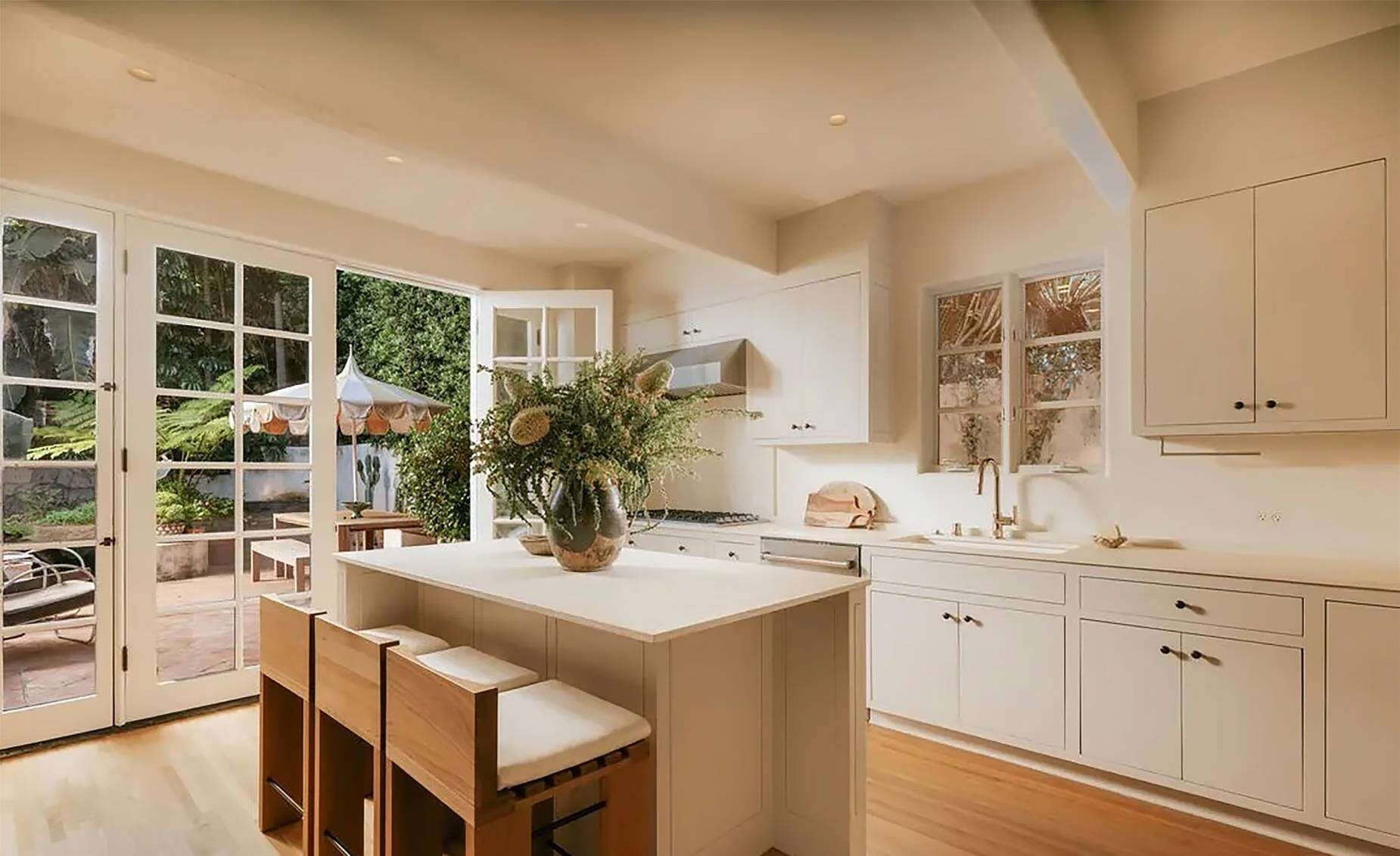 The home’s bright kitchen opens directly onto the backyard through large glass doors.