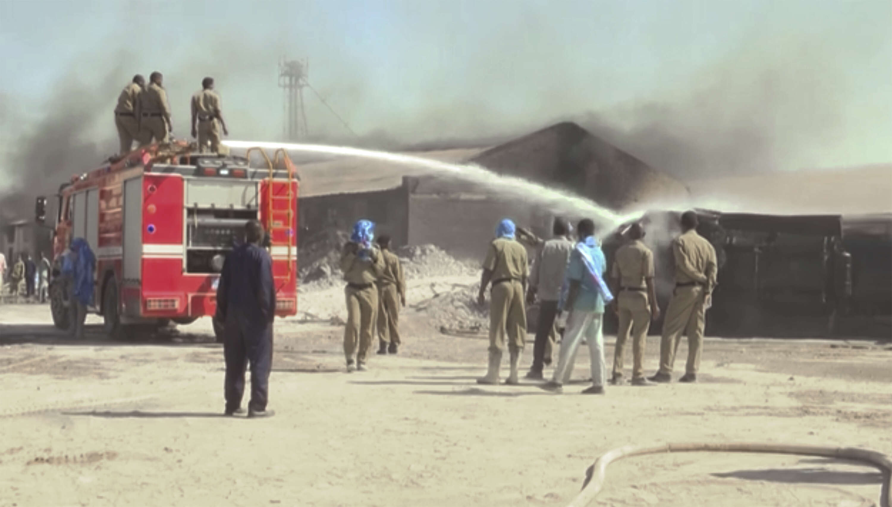 Firefighters try to put out a fire at a tile factory in Khartoum, Sudan (AP)