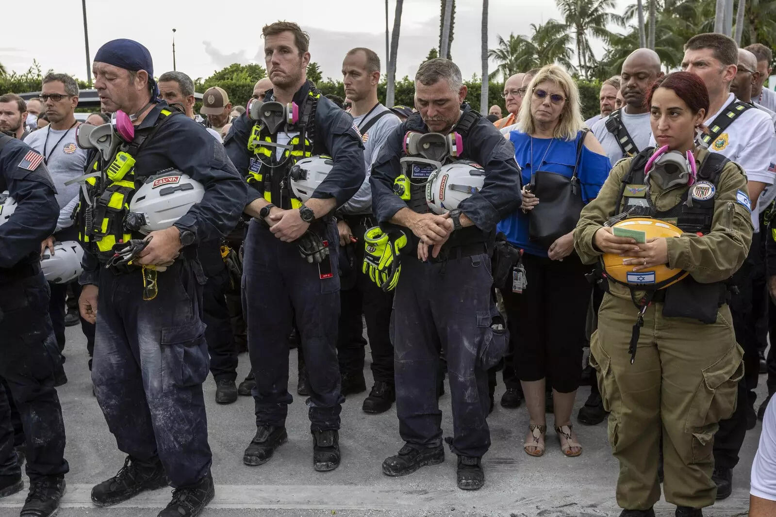 Members of search and rescue teams gathered for a moment of prayer and silence next to the collapsed tower. ( AP Photo)