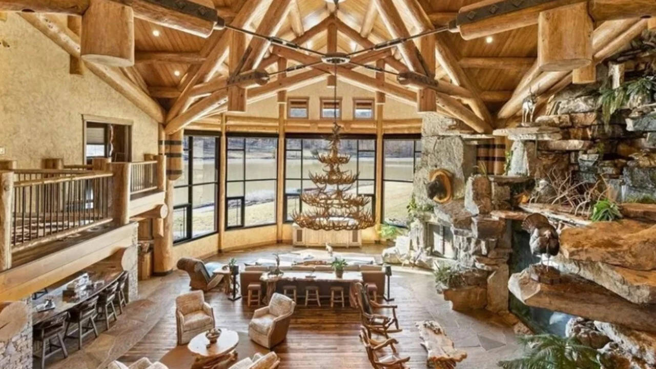 The great room features a stone fireplace and a wall of windows.