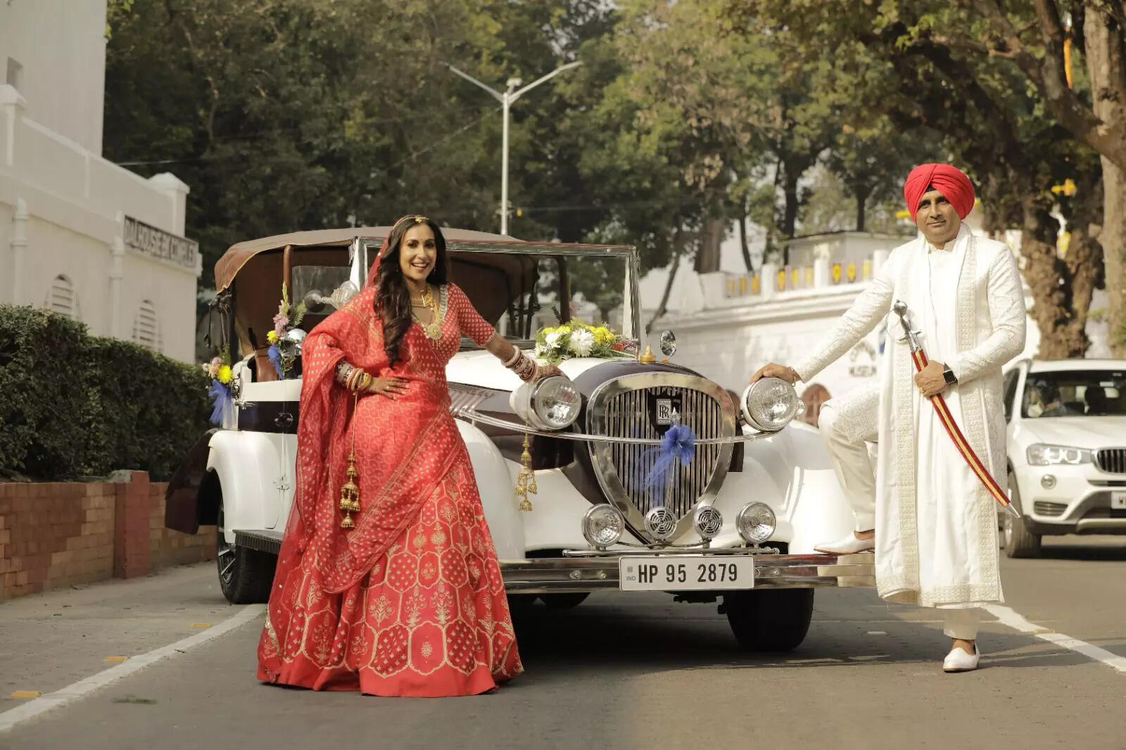 Sayani and her husband Gurvinderjit Samra posing infront of the vintage car.