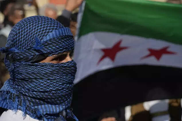 A Syrian man stands in front of a flag during a spontaneous demonstration celebrating the fall of the Assad regime in Nicosia, Cyprus, Sunday, December 8, 2024. (AP)