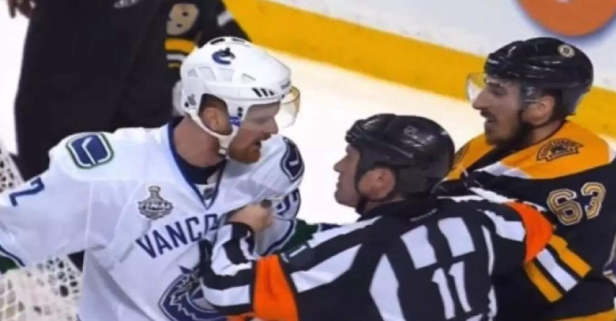 Kelly Sutherland gives Daniel Sedin an explanation as to why being punched in the head by Brad Marchand is a penalty.