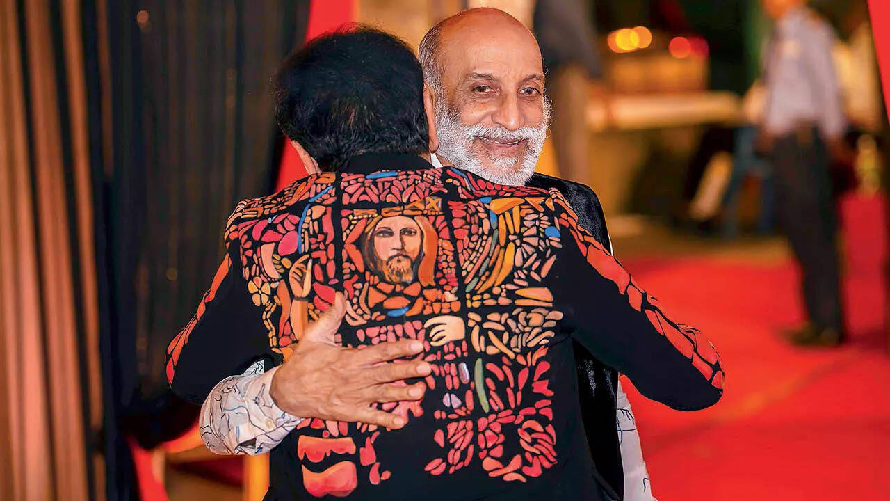 Dressed in a black hand-painted jacket, Rajinder Bagga hugs Aman Nath