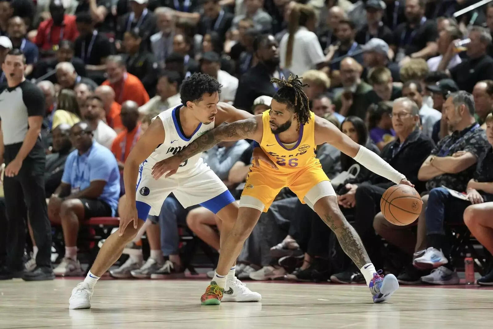 Los Angeles Lakers guard RJ Davis (26) dribbles against Dallas Mavericks guard Ryan Nembhard (9) in the first quarter of their game at Thomas & Mack Center