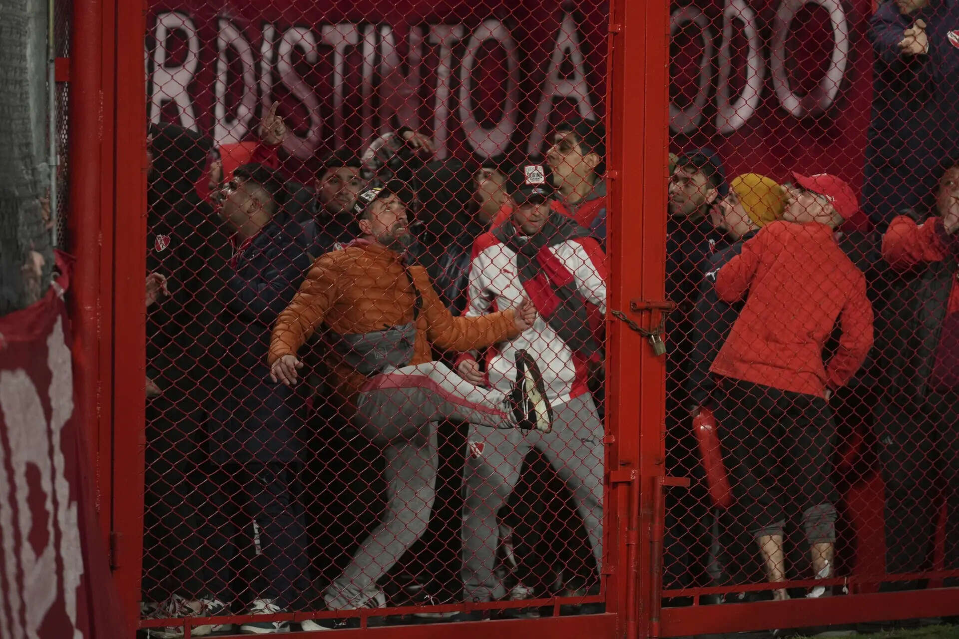 Fans of Argentina's Independiente bang on a barrier during a Copa Sudamericana round of sixteen second leg soccer match against Universidad de Chile at the Libertadores de America stadium in Avellaneda, Argentina, Wednesday, Aug. 20, 2025. (AP Photo/Gustavo Garello) More than 100 Chilean fans arrested after violence in the stands during soccer match in Argentina
