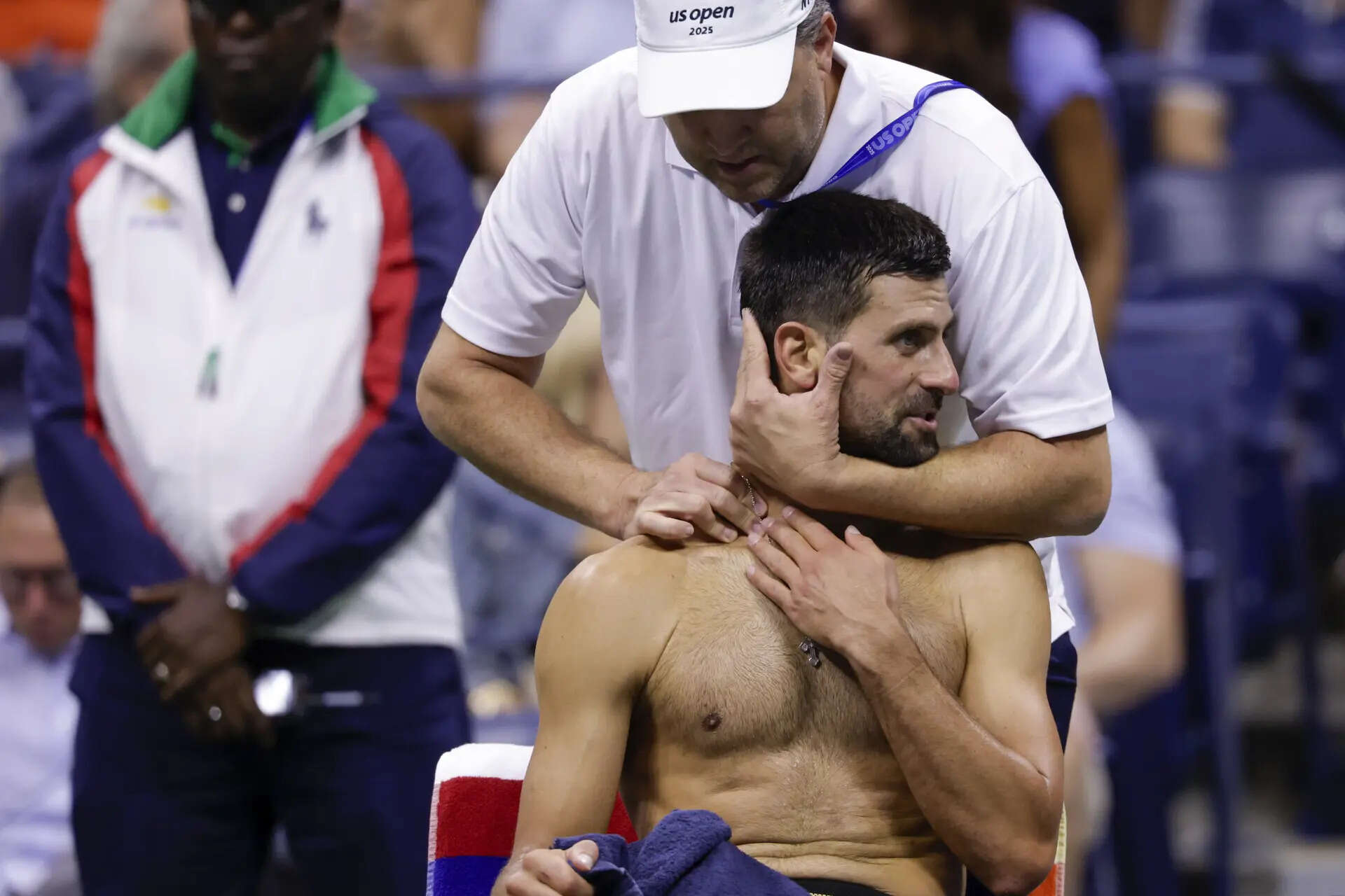 A trainer works on Novak Djokovic, of Serbia, between games against Jan-Lennard Struff, of Germany, during the fourth round of the U.S. Open tennis championships, Sunday, Aug. 31, 2025, in New York. (AP Photo/Andres Kudacki) Novak Djokovic's neck bothers him during a US Open win. He will face Taylor Fritz next