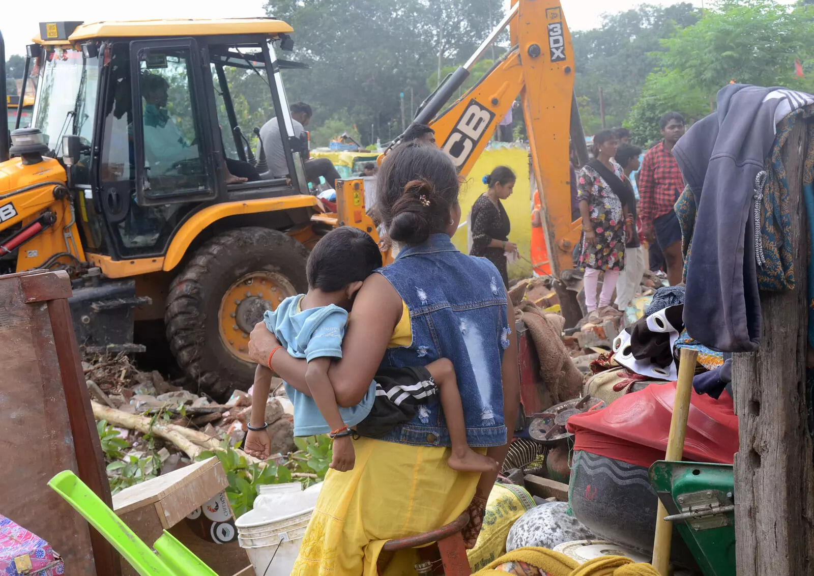 An earthmover razes huts near Birsa Chowk