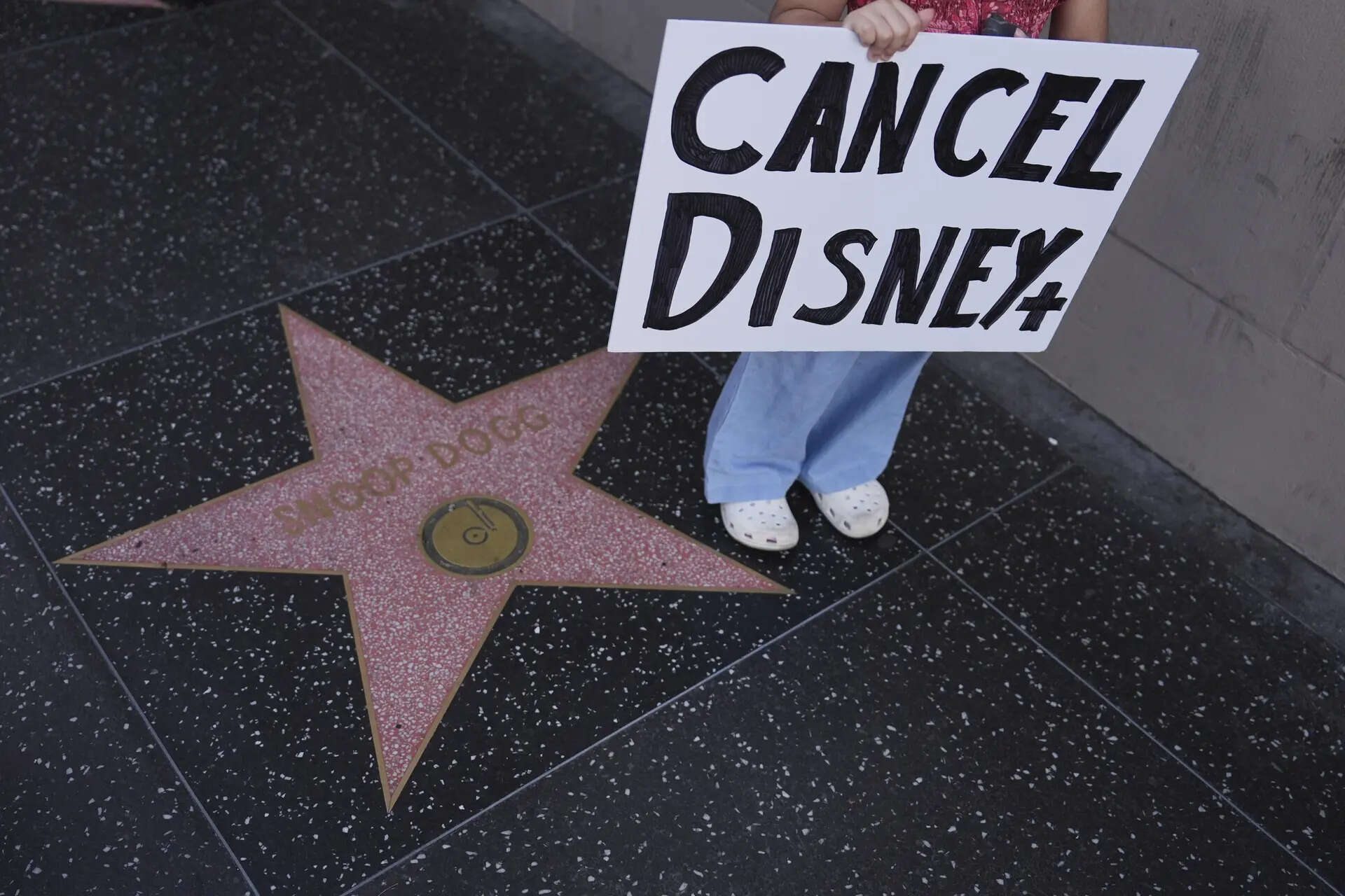 A demonstrator holds a sign reading Jimmy Kimmel