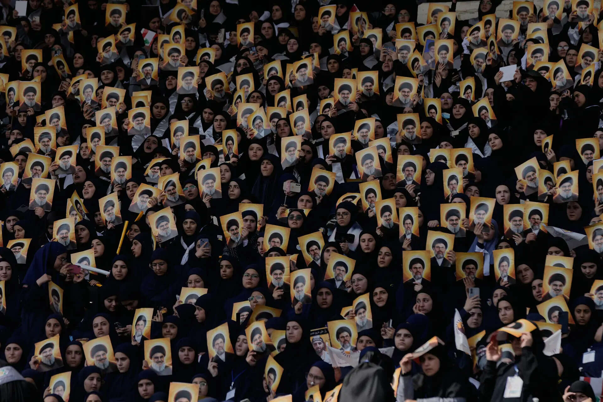 Hezbollah's al-Mahdi Scouts hold pictures of Hezbollah's former leader Hassan Nasrallah and his cousin and successor Hashem Safieddine, to marking the first anniversary of their assassination, who were killed in Israeli airstrikes, at Sports City Stadium in Beirut, Lebanon, Sunday, Oct. 12, 2025. (AP Photo/Bilal Hussein) Lebanon Nasrallah Anniversary