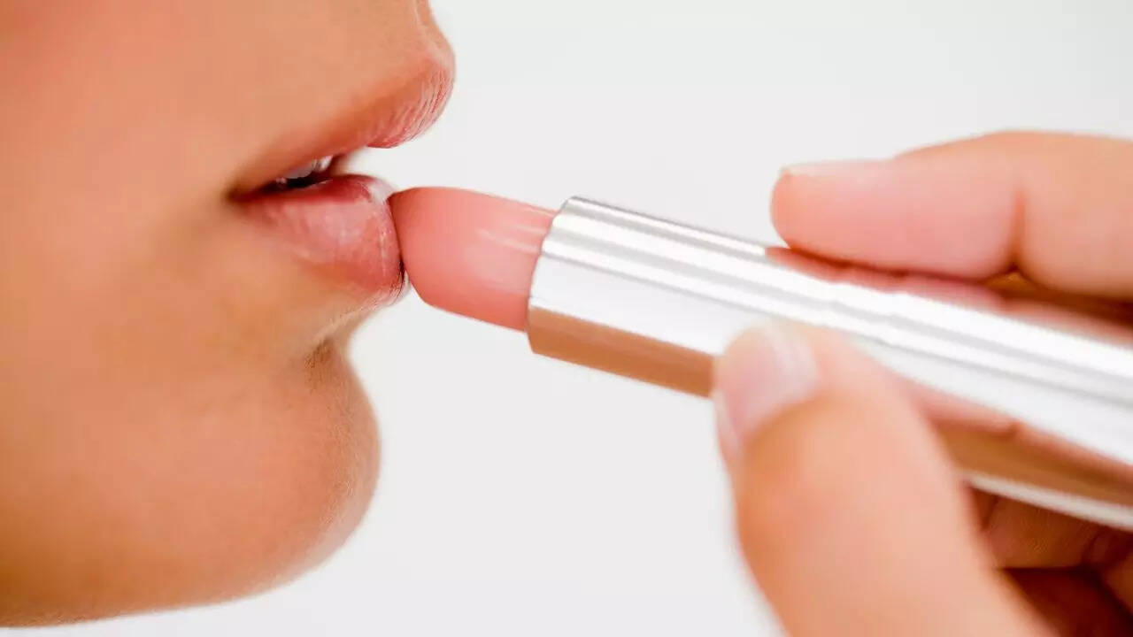 Credit: Canva Applying Lipstick