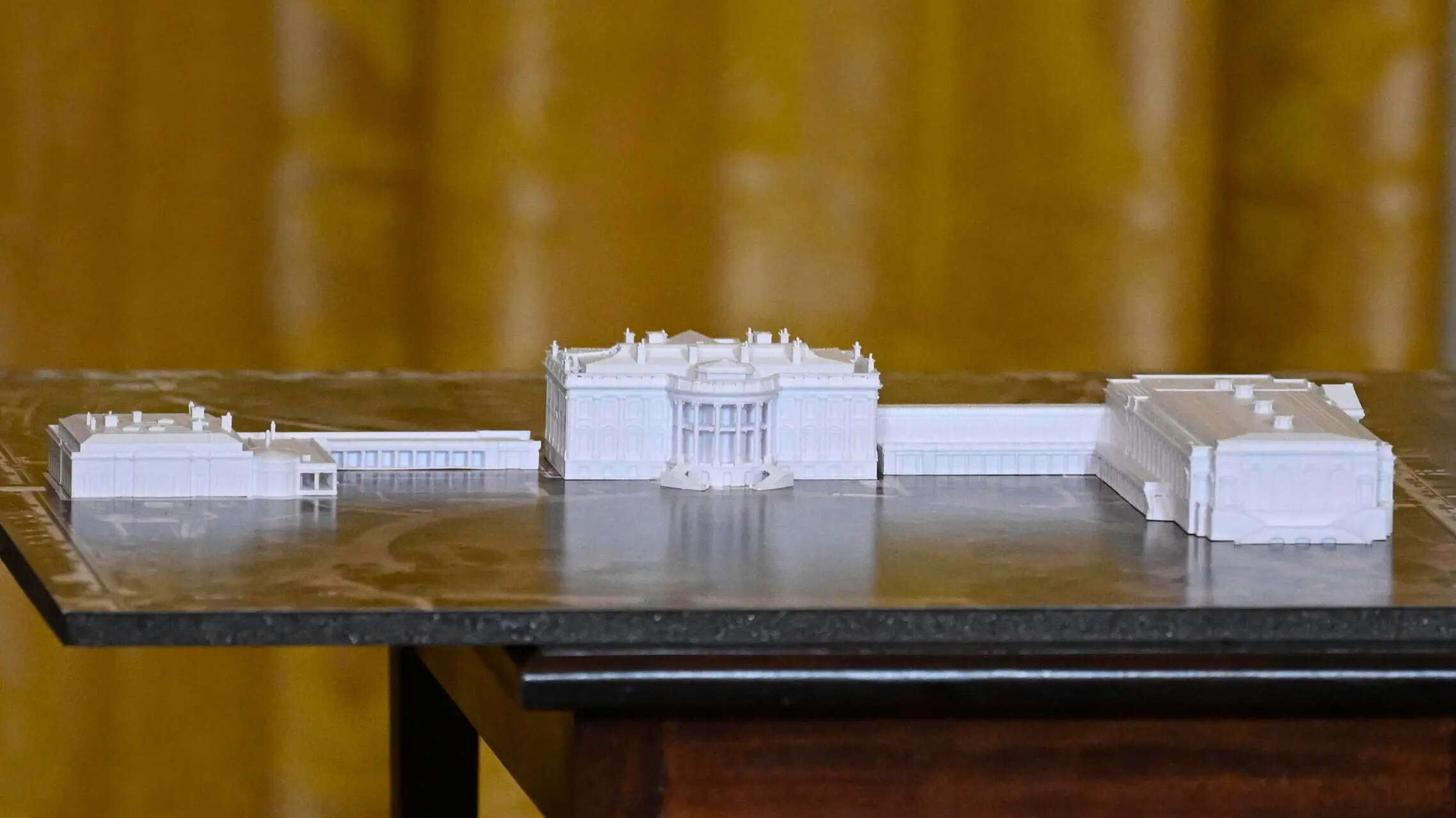 A model is seen as President Donald Trump addresses a dinner for donors who have contributed to build the new ballroom at the White House, Wednesday, Oct. 15, 2025, in Washington. (AP Photo/John McDonnell) The White House starts demolishing part of the East Wing to build Trump's ballroom