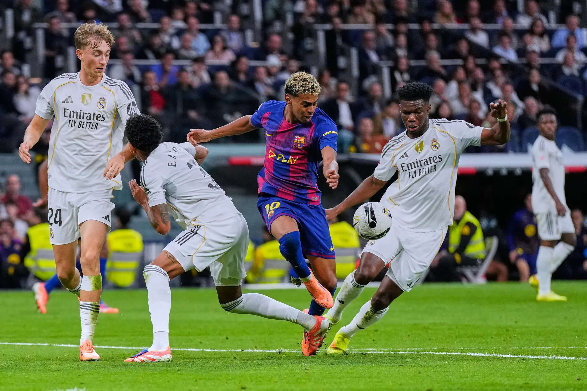 Barcelona's Lamine Yamal, center, tussles for the ball with Real Madrid defenders during the Spanish La Liga soccer match between Real Madrid and Barcelona, in Madrid, Sunday, Oct. 26, 2025. (AP Photo/Manu Fernandez) Spain Soccer La Liga
