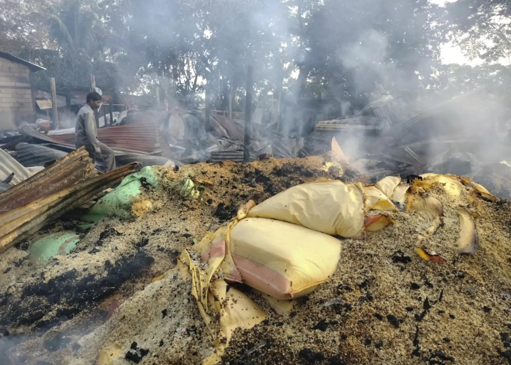 Smoke billows out from a vandalised area following violent protests demanding eviction of encroachers from tribal belts, at Kheroni, in Karbi Anglong district