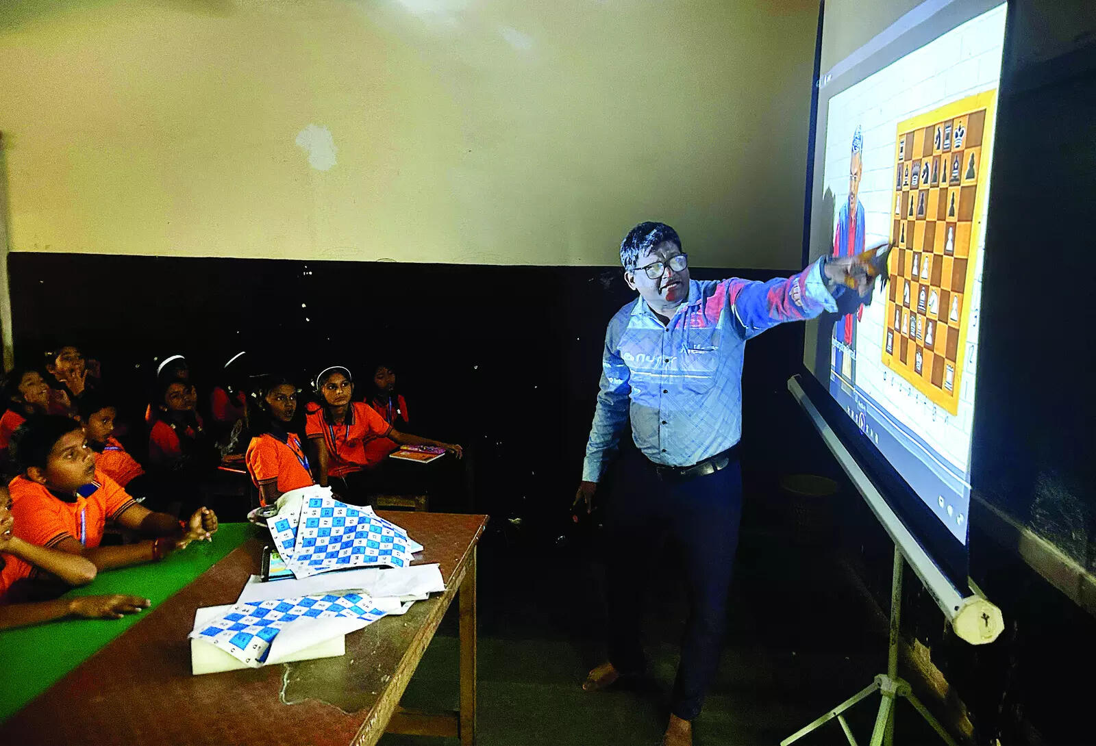 Goa plots its moves, focuses on primary schools for chess champs | Goa News <div>Students listen attentively to coach Nilesh Dhargalkar, who uses a projector during a chess class</div>