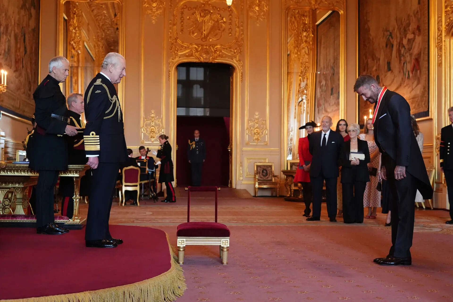 Bend a knee like Beckham: Soccer star is knighted by King Charles III