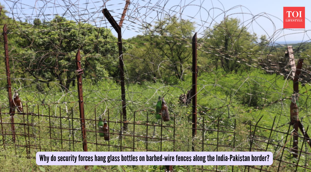 Why do security forces hang glass bottles on barbed-wire fences along the India-Pakistan border?