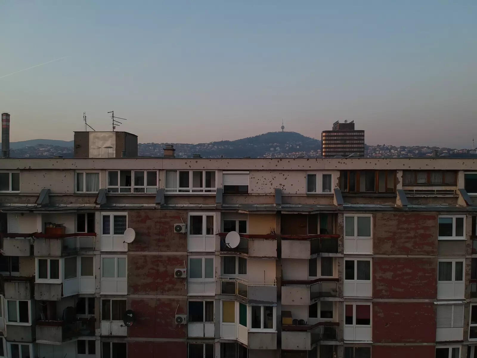 A multi-story residential building still has bullet holes on its walls and balcony in Sarajevo, Bosnia & Herzegovina (PC - Chan Siu Ki, Hong Kong)