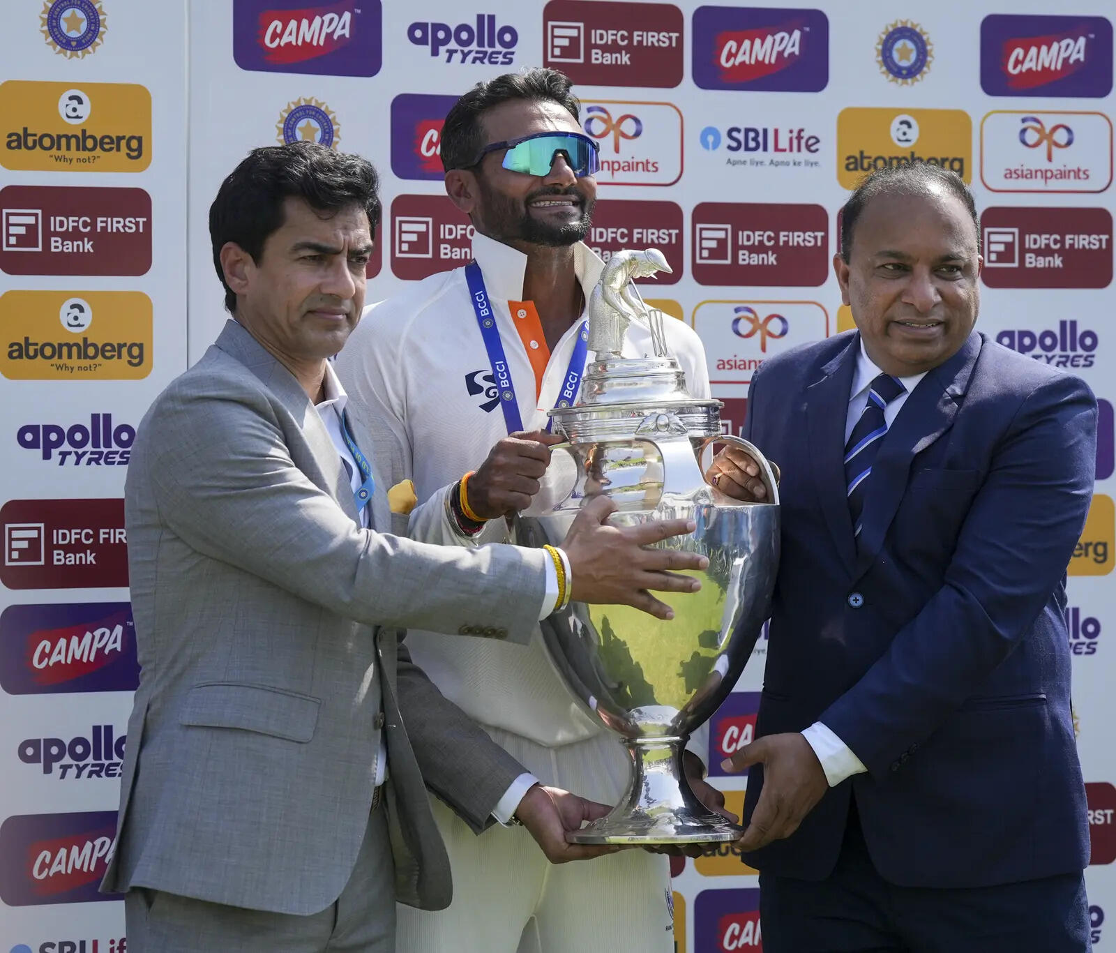 BCCI President Mithun Manhas (L), secretary Devajit Saikia (R) hand over the Ranji Trophy title to J&K's Paras Dogra. (PTI) J-K wins