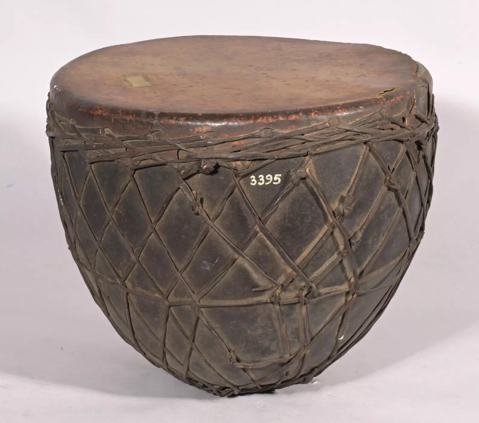 This percussion instrument is a rhythmic masterpiece, carved into a graceful conical form with a hollowed interior that amplifies its deep, resonant voice
