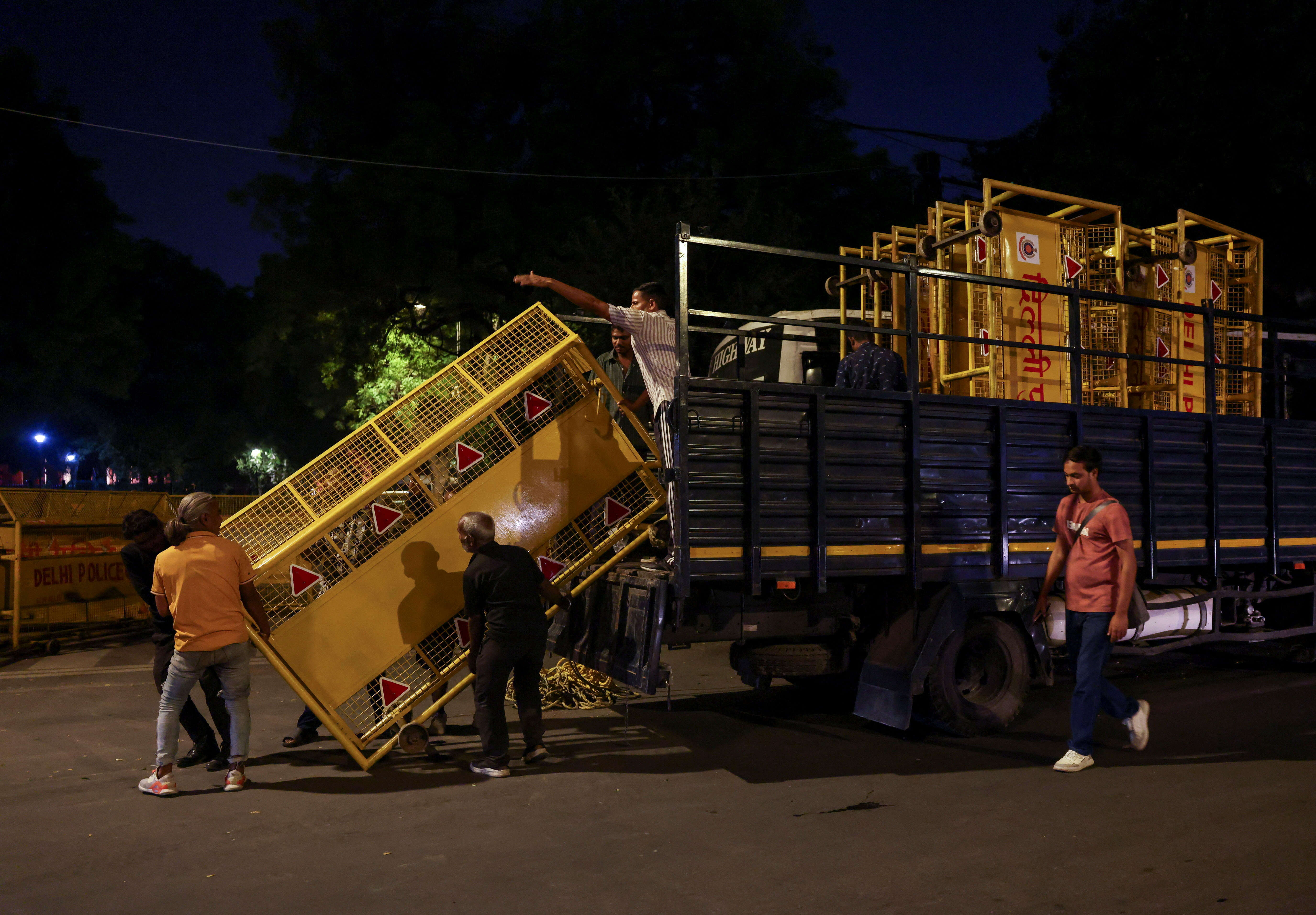 People unload barricades from a police vehicle ahead of a protest planned by the Cockroach Janta Party (CJP) (Image Credit: Reuters)
