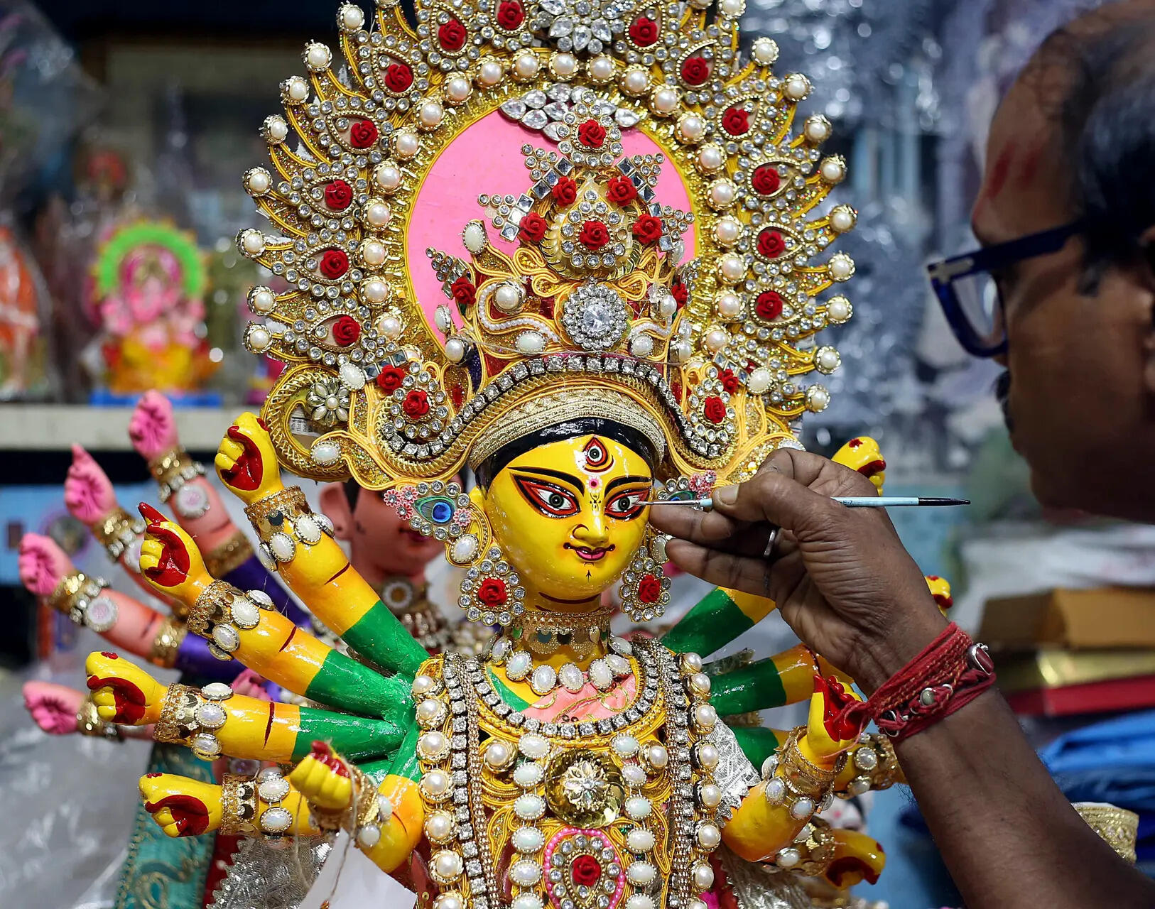 An artisan prepares the idol of Goddess Durga ahead of the Durga Puja festival at Kumartuli, in Kolkata on Sunday