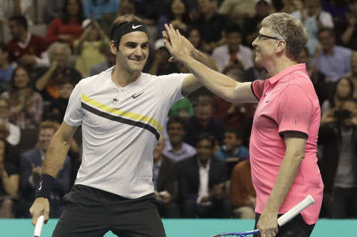 What is Bill Gates doing with Roger Federer on a tennis court?