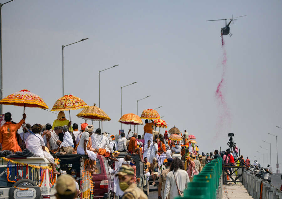 A chopper showers flower petals on Akhada sadhus arriving to take bath at Har Ki Pauri April 14.