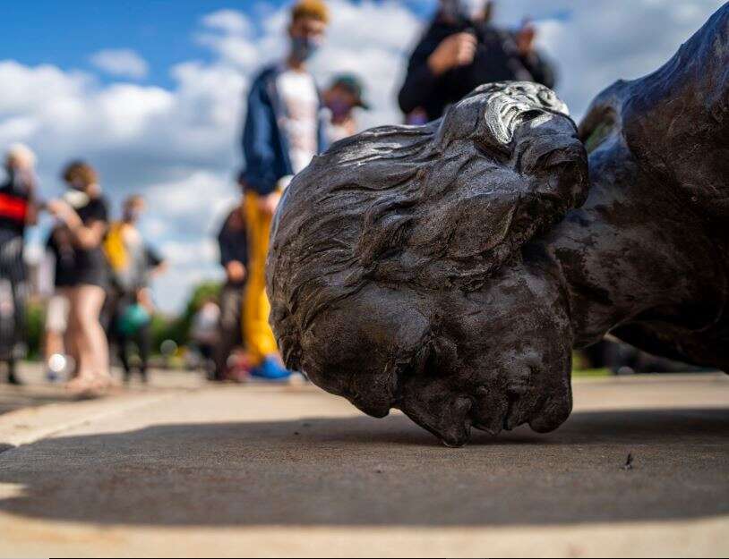 People stand around the fallen Christopher Columbus statue at the Minnesota state Capitol in St. Paul, Minn (AP Photo)