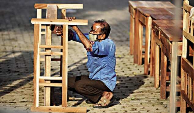 A carpenter selling furniture on the roadside in Thiruvananthapuram giving finishing touches to his work on Friday