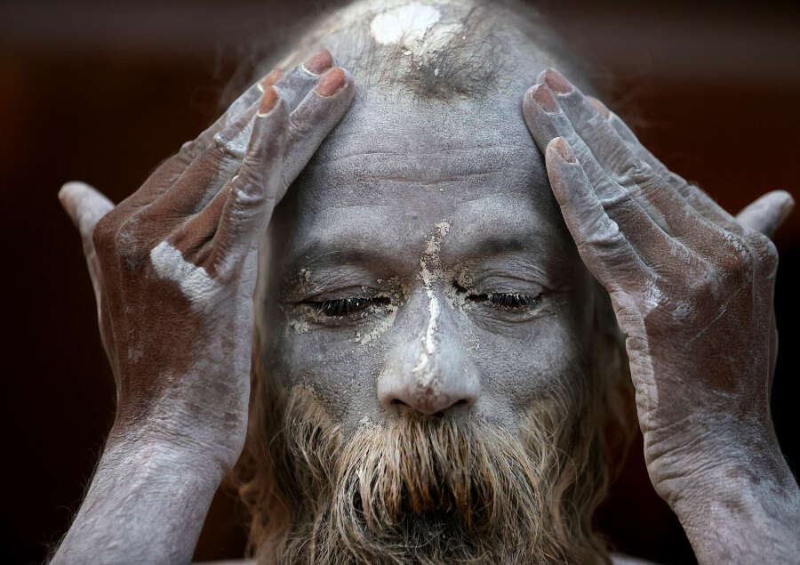 A Naga Sadhu rubes ash as he prepares to take holy dips in the river Ganges during Shahi snan (Credit:AP)