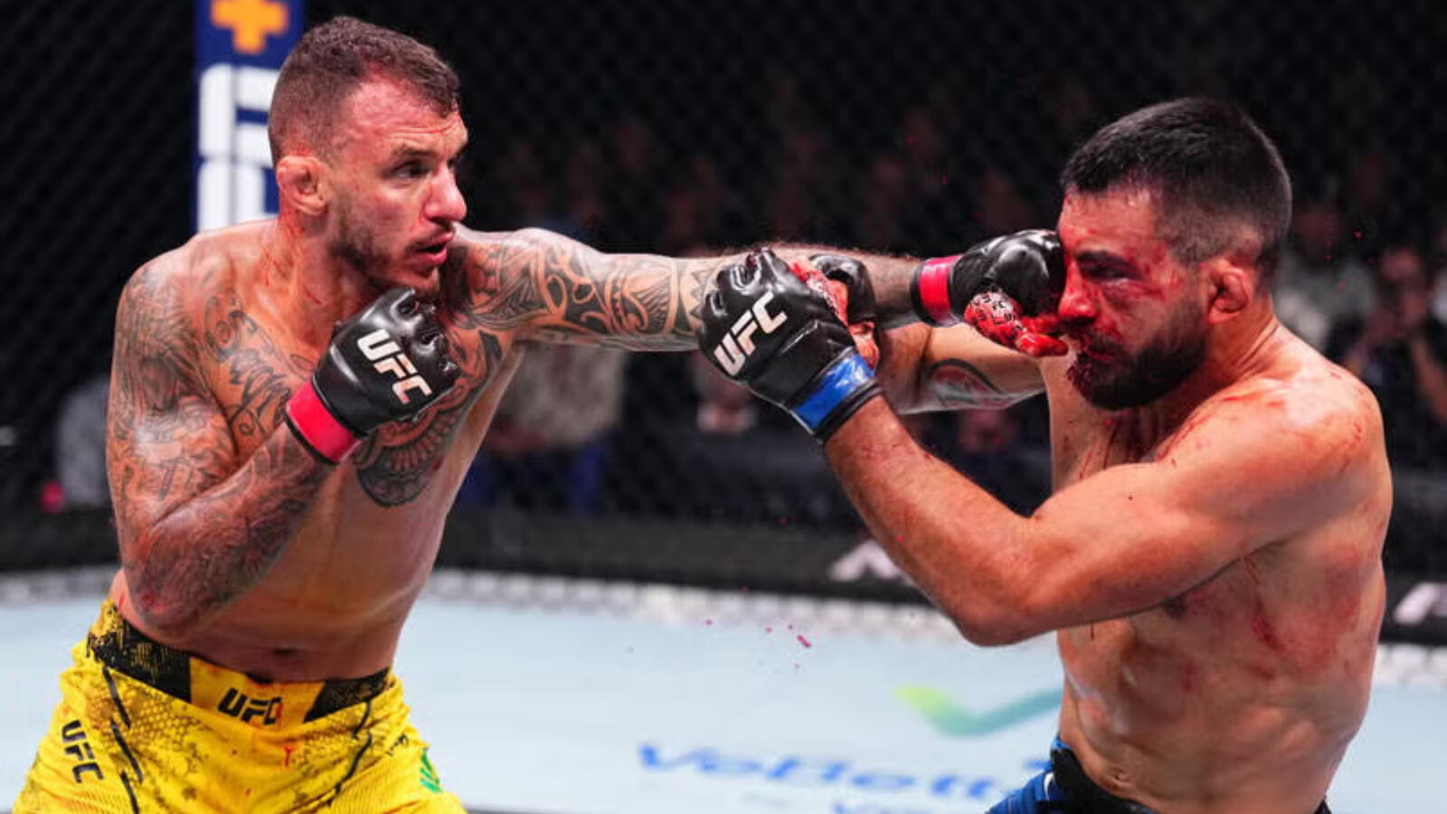 Renato Moicano punches Benoit Saint Denis in a lightweight fight during the UFC Fight Night event at The Accor Arena on September 28, 2024 in Paris, France