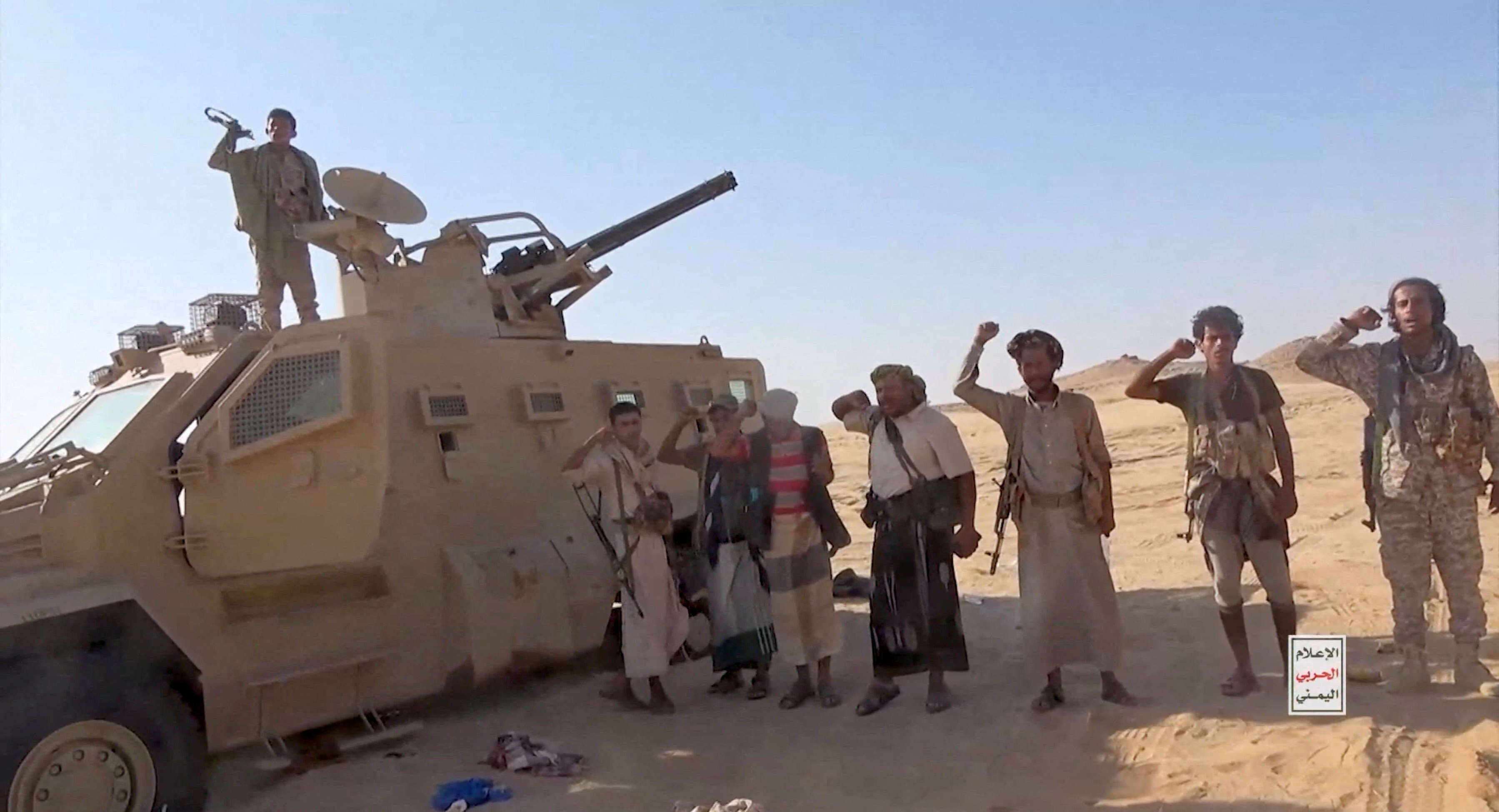 Iran-aligned Houthi fighters pose next to a captured vehicle following what the source described as an attack on Saudi-backed forces in the location given by the source as al Jawf governorate, Yemen,